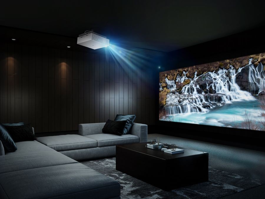 A casual home theater with a sectional, projector, and large movie screen.