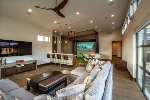 A luxury media/entertainment area in a Hawaii home with a custom golf simulator