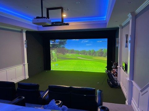 View of a golf simulator setup inside a home theater.