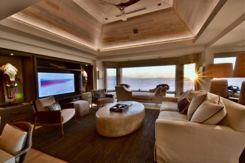 Luxury Hawaii home with motorized shades revealing views of the ocean.