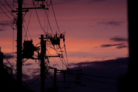 The silhouette of an electrical transformer in the sunset.