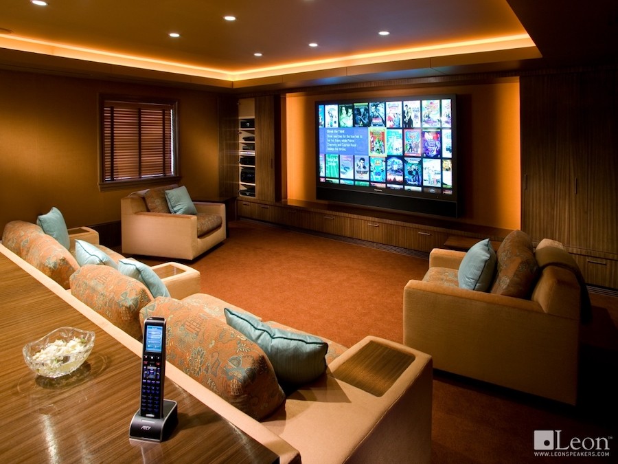 A home theater with Leon speakers, plush seats, and a large movie screen. 