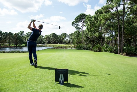 A man playing golf outside on a beautiful day. 