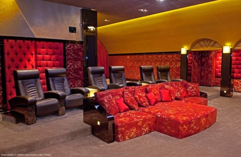 red and black home theater seating in a luxury entertainment room with tiered rows